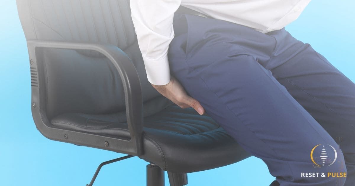 Cadre en costume souffrant d'une sciatique au bureau dans un contexte de stress professionnel